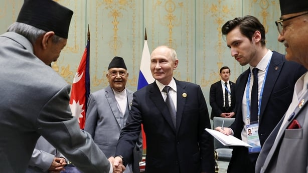 Vladimir Putin attending a meeting with Nepal's Prime Minister KP Sharma Oli and shaking hands with other attendees
