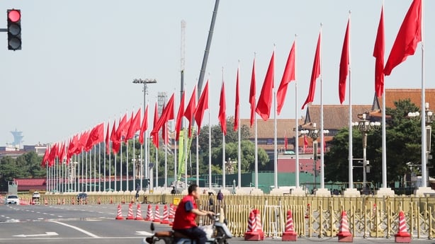 A row of Chinese national flags flying along a street in Beijing, China.