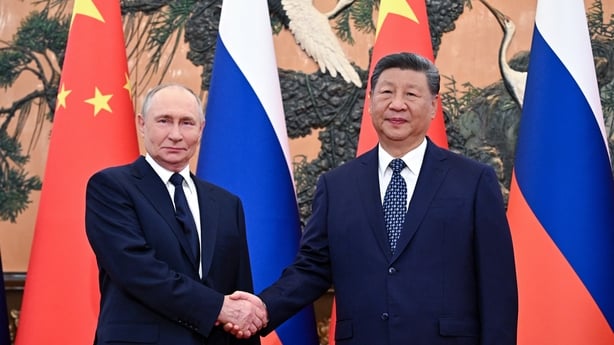 Russia's President Vladimir Putin shakes hands with China's President Xi Jinping.