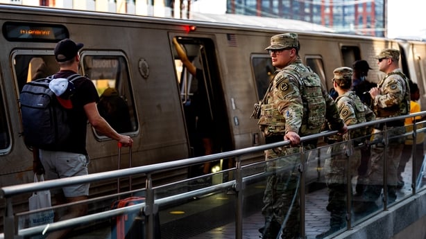 Armed members of the National Guard stand guard at NoMa-Gallaudet metro station in Washington DC.