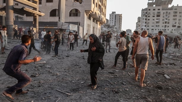 Palestinians rush away in panic from the area following an Israeli army strike on the al-Ruya Tower in Gaza City