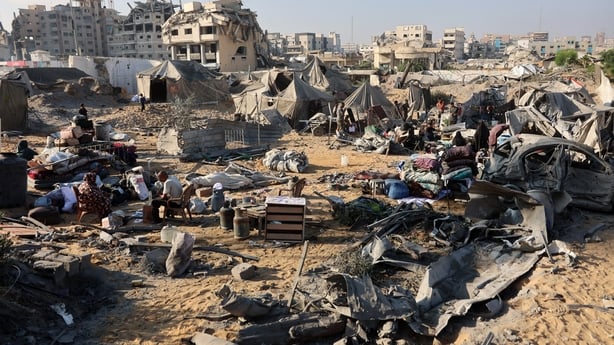 Displaced Palestinians check what remains of their tents following an Israeli strike