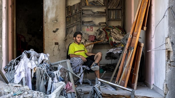 A man sits in an exposed room in a heavily damaged building in Gaza city
