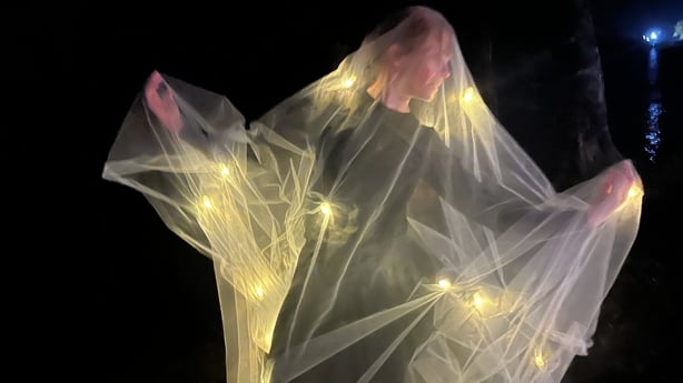 Artist Linda Schirmer wearing fairy lights and a muslin cloak