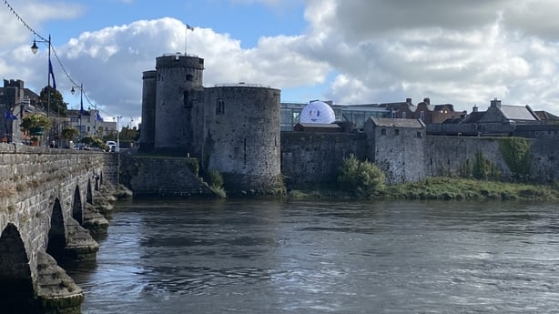 A giant golf ball sits atop castle walls