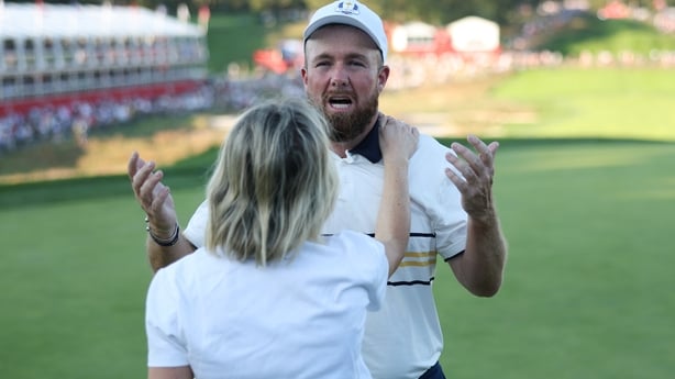 FARMINGDALE, NEW YORK - SEPTEMBER 28: Shane Lowry of Team Europe celebrates with his wife Wendy after Lowry made his putt to halve the hole and retain the Ryder Cup during the Sunday singles matches of the 2025 Ryder Cup at Black Course at Bethpage State Park Golf Course on September 28, 2025 in Far