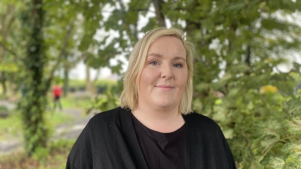 A woman stands in a garden 