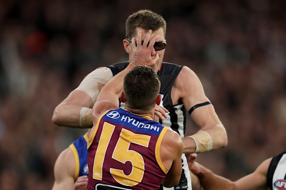The eyewear of Mason Cox of the Magpies is knocked off his head by Dayne Zorko.