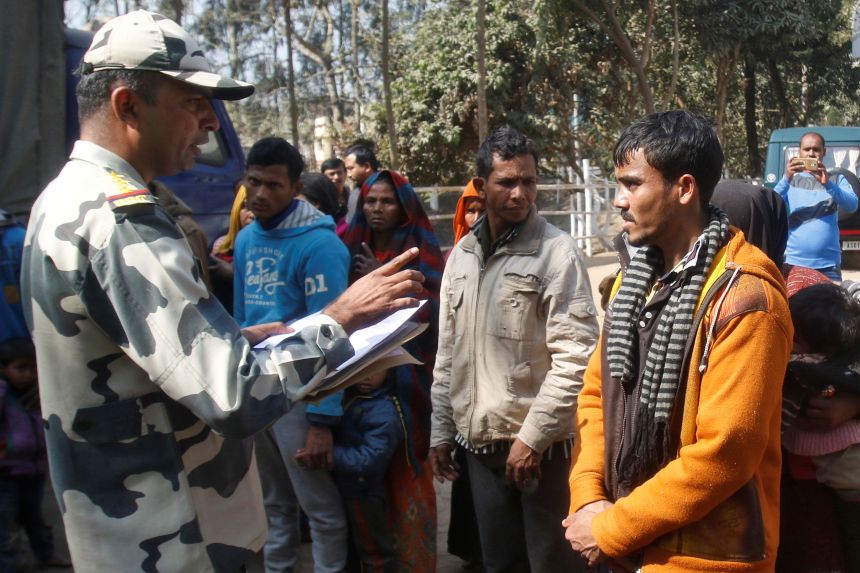 A Border Security Force official registers the names of Rohingya Muslims after they were detained while crossing the India-Bangladesh border from Bangladesh on the outskirts of Agartala, India, in January 2019.