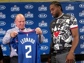 Los Angeles Clippers team chairman Steve Ballmer presents a jersey to Kawhi Leonard during a press conference in Los Angeles in 2019.