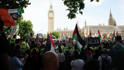 PA Media A large crowd, with many holding Palestinian flags, stands in front of the Houses of Parliament