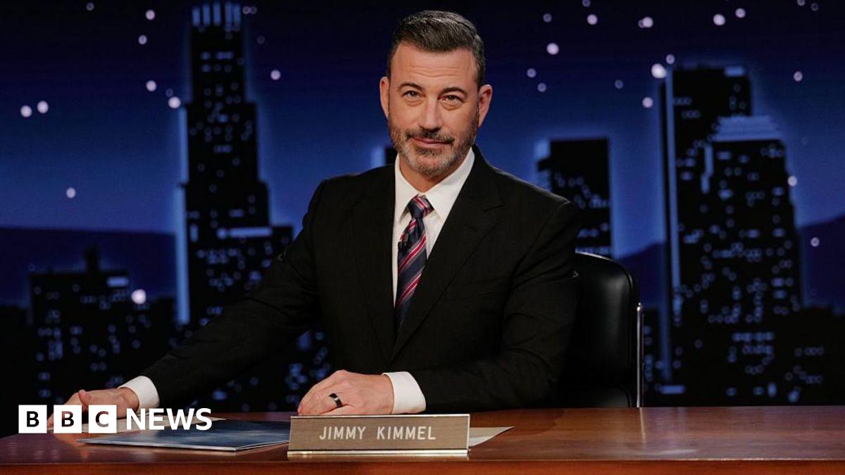 Jimmy Kimmel sits at his desk on his late night show