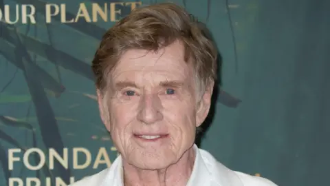Getty Images Robert Redford headshot, he is wearing a white shirt and jacket