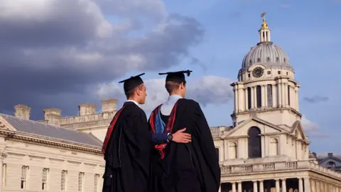 Universal Images Group via Getty Images Male students at the University of Greenwich posing for pictures on graduation day in the grounds of the Old Royal Naval College in London.