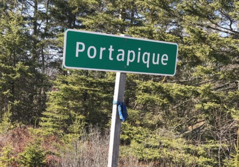 the green roadsign to Portapique with a tartan sash tied around the post