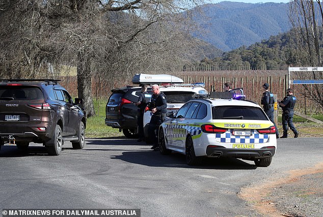 A man has been detained as part of the ongoing search Dezi Freeman after heavily-armed officers descended on a home in Myrtleford (pictured, police in Porepunkah)