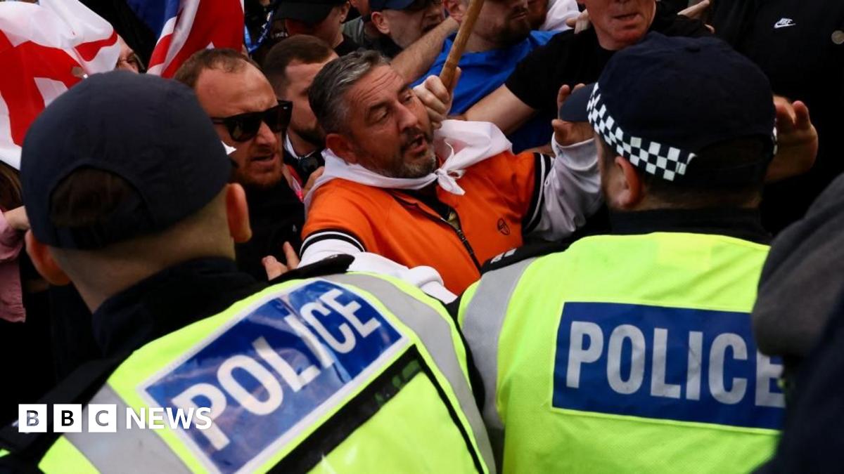 Protesters demonstrating an asylum hotel in Epping pushed up next to police officers in high vis jackets