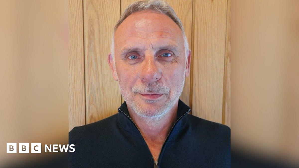 A row of black Range Rover cars on a production line