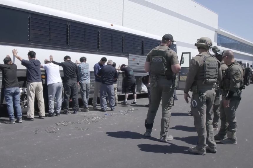 This image from video provided by US Immigration and Customs Enforcement shows manufacturing plant employees waiting to have their legs shackled at the Hyundai Motor Group’s electric vehicle plant, in Ellabell, Georgia, on September 4, 2025.