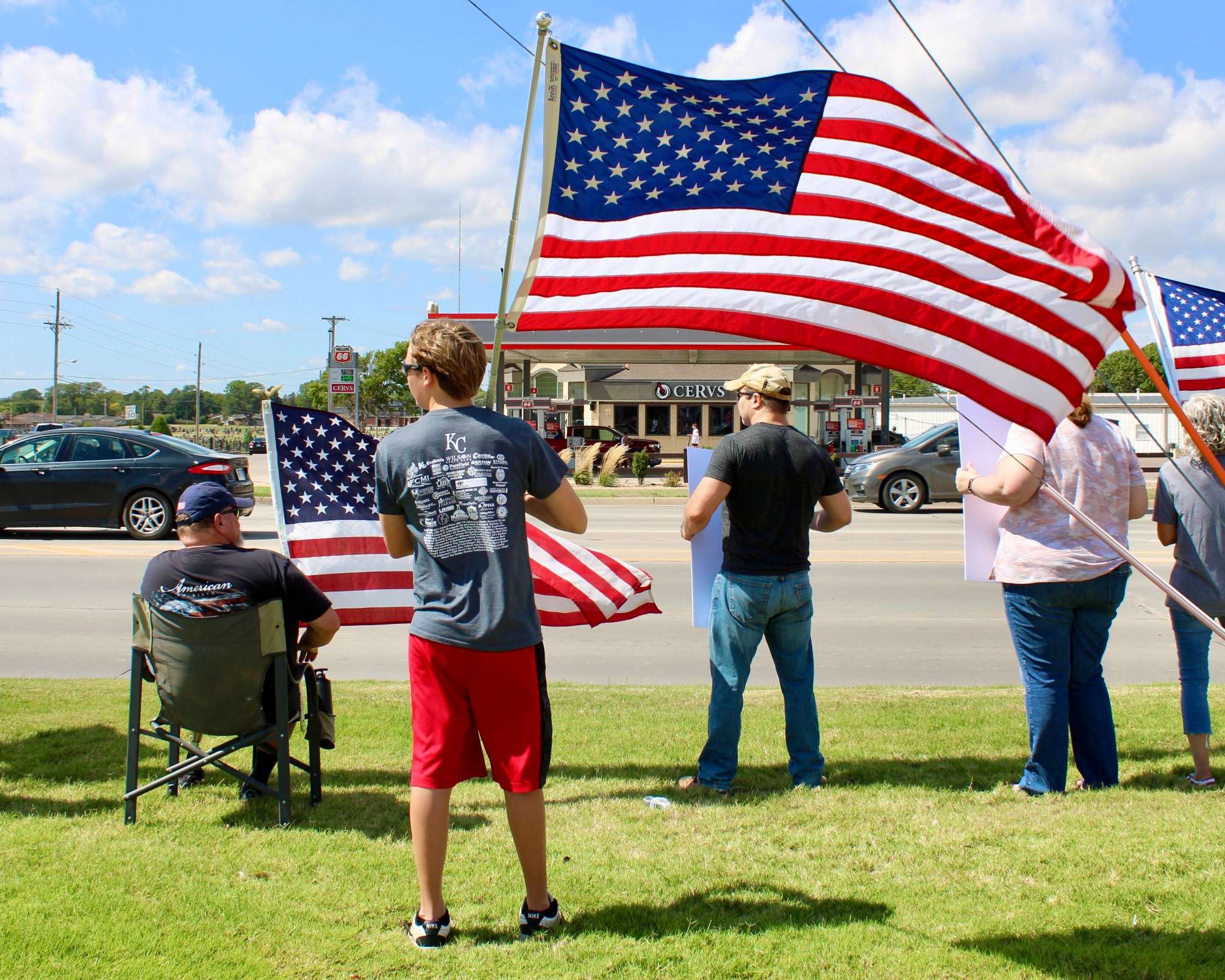 An attendee with the American flag on the corner of 27th and Vine in Hays. Photo by Tony Guerrero/Hays Post