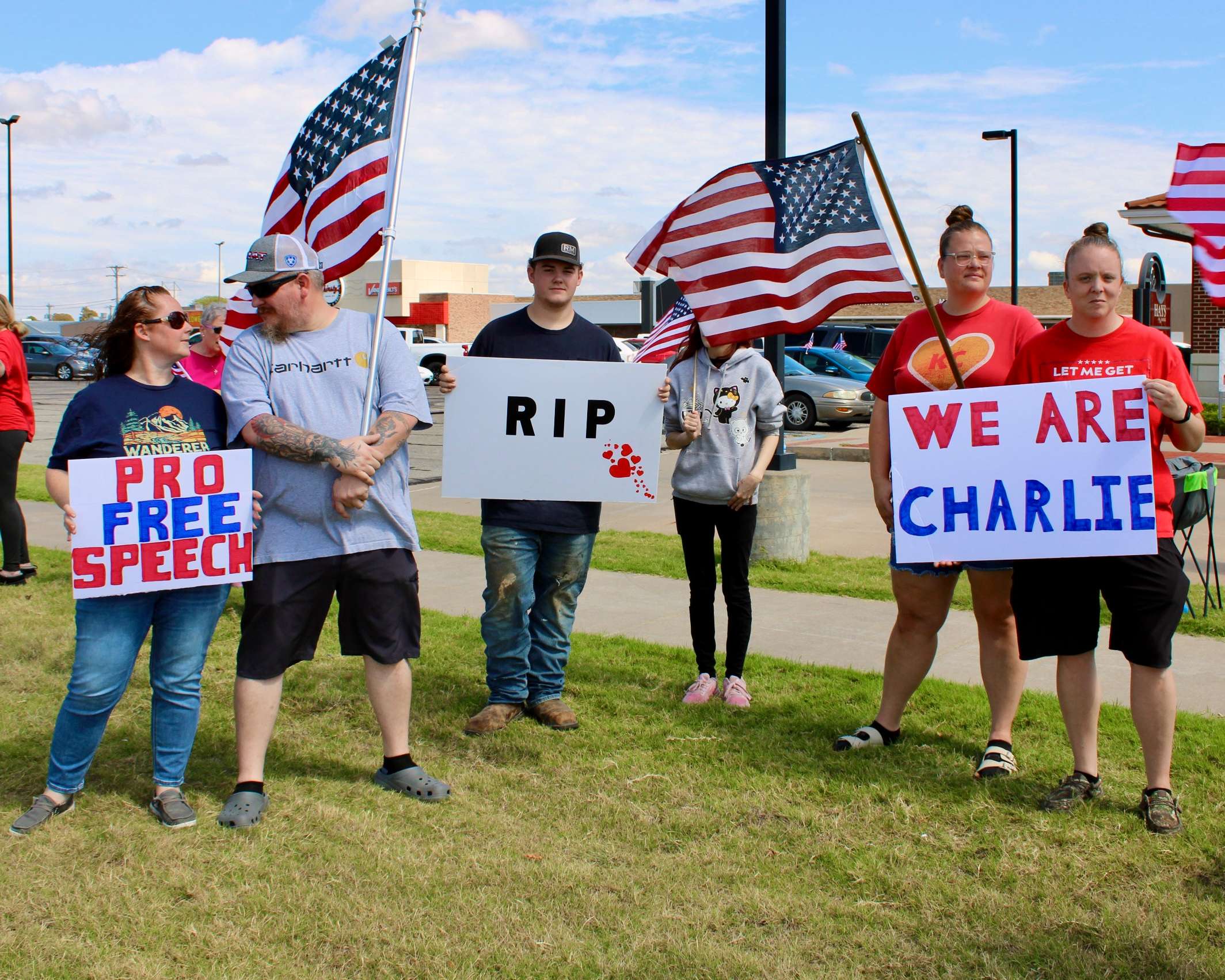 Attendees with the American flags, and signs on the corner of 27th and Vine in Hays. Photo by Tony Guerrero/Hays Post