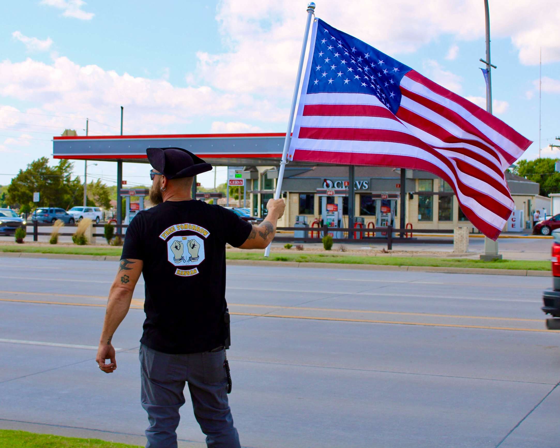 David Koshiol with an American flag on the corner of 27th and Vine in Hays. Photo by Tony Guerrero/Hays Post