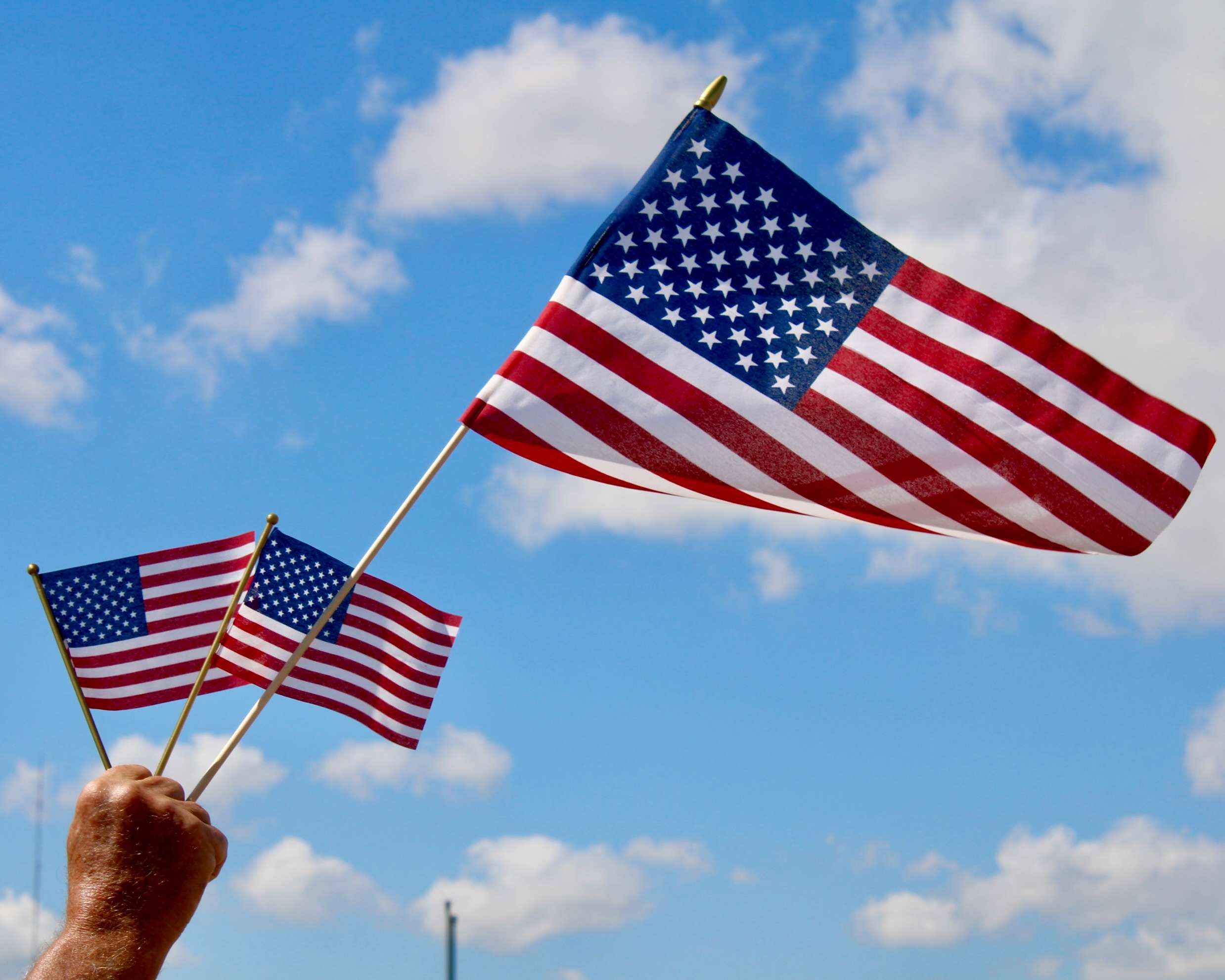 A man holding American flags. Photo by Tony Guerrero/Hays Post