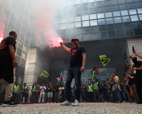 Strikers holding flares and flags inside the building