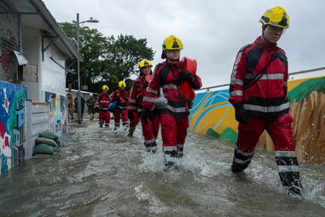 Firefighters walk through the flood waters in Lei Yue Mun area as super typhoon Ragasa approaches in Hong Kong, on Wednesday.