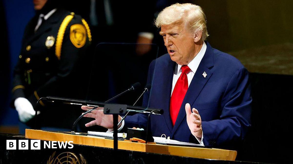 President Donald Trump wearing a blue jacket and red tie gestures with his hands as he stands at a lectern during the 80th session of the UN’s General Assembly (UNGA) at the United Nations headquarters on September 23, 2025