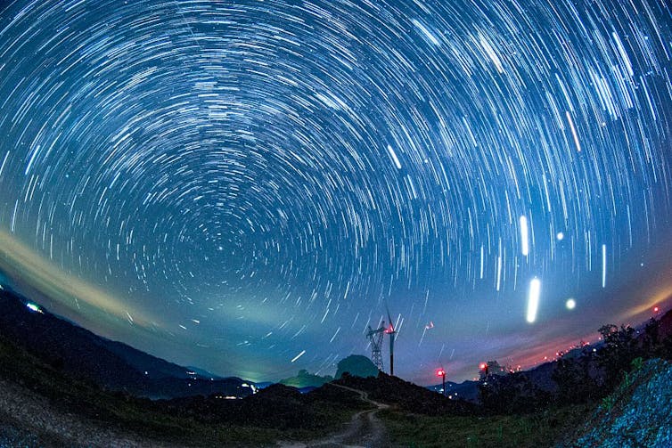 A wind farm under a starry sky.