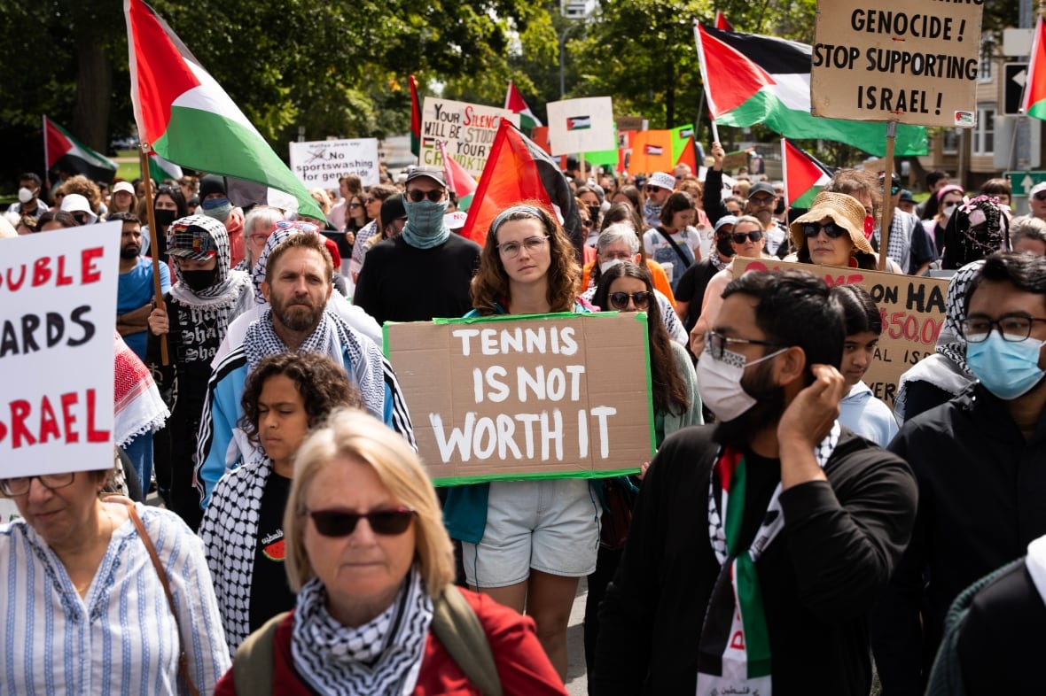 Hundreds of demonstrators block a street while protesting.