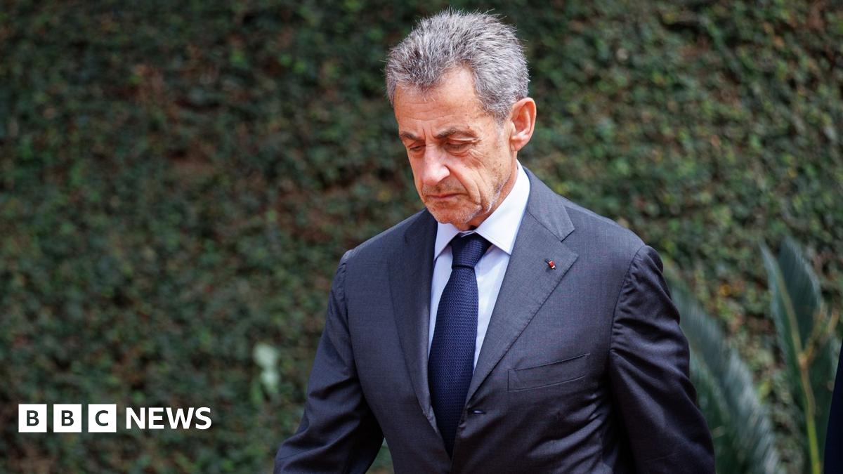 A resident walks with a shovel along a mud-covered road in Hualien on September 24, 2025, following the bursting of a barrier lake during the passing of Super Typhoon Ragasa.