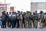 Masked-up federal agents approach the protesters in the driveway of the Immigration and Customs Enforcement facility in Portland, Ore., on Sept. 28, 2025.