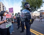 Protesters hold signs reading "End Deportations, Abolish ICE" while confronting with Department of Homeland Security agents near the Immigration and Customs Enforcement facility in Portland, Ore., on Sept. 28, 2025.