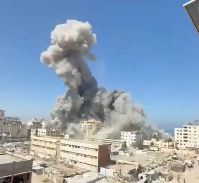 A large plume of smoke over a building