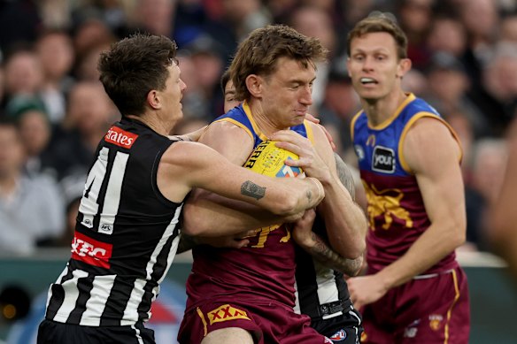 Harris Andrews of the Lions is tackled by Brody Mihocek.