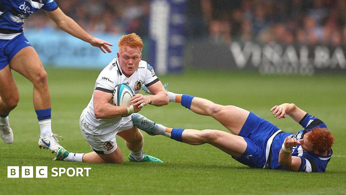 Exeter's Ben Hammersley, in white, goes to ground with two Bath defenders trying to tackle him.