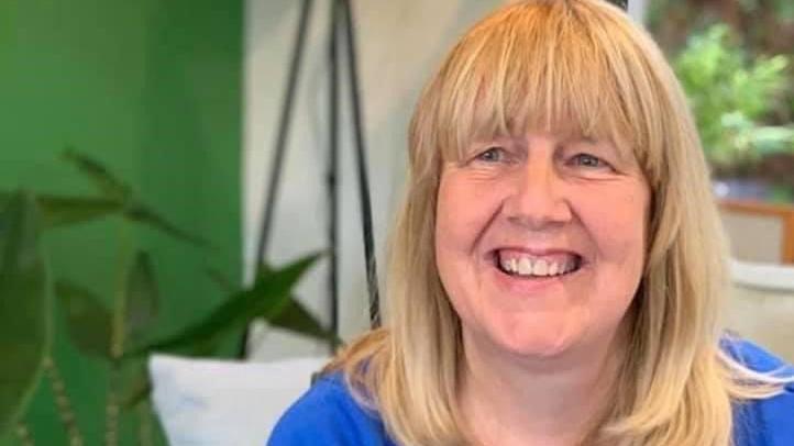 Mary Delargy smiling at the camera, she has blonde hair and is wearing a blue top. 