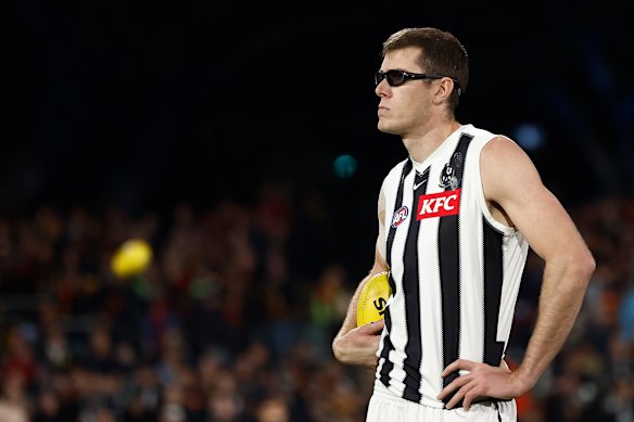 Mason Cox of the Magpies looks on.