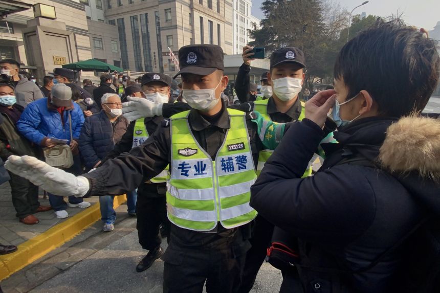 Police attempt to stop journalists from recording footage outside the Shanghai Pudong New District People's Court, where Chinese citizen journalist Zhang Zhan is set for trial in Shanghai on December 28, 2020.
