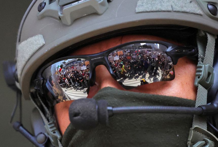 Protesters are reflected in the sunglasses worn by a law enforcement officer during protests against immigration sweeps in Los Angeles, California, June 9, 2025.