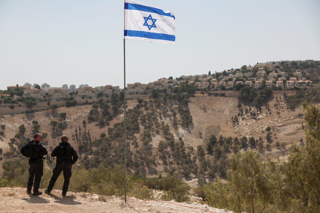 Israeli flag flutters, as part of the Israeli settlement of Maale Adumim is visible in the background, in the Israeli-occu...