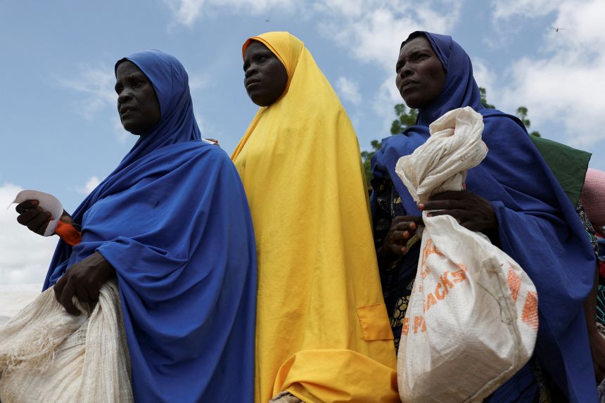 Women from different internally displaced persons camps hold food sacks while waiting in line to receive support at a WFP distribution centre in Dikwa.