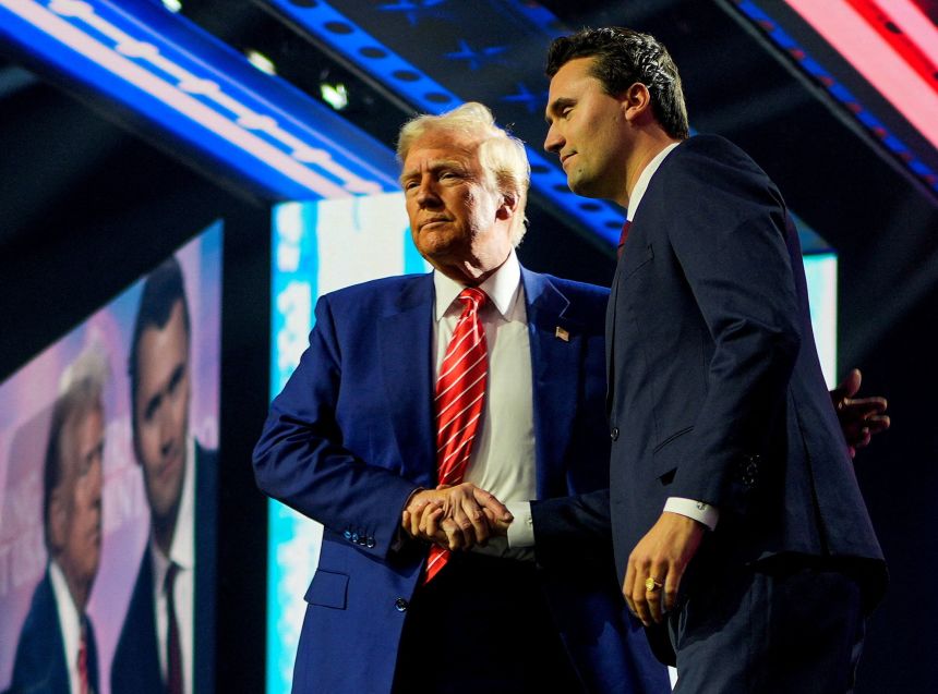 Then-President-elect Donald Trump shakes hands with Turning Point USA founder Charlie Kirk at Turning Point USA's AmericaFest in Phoenix, Arizona on December 22, 2024.
