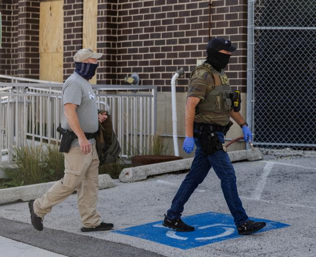 Two federal agents walk towards an entrance of the Broadview ICE detention facility in Illinois....
