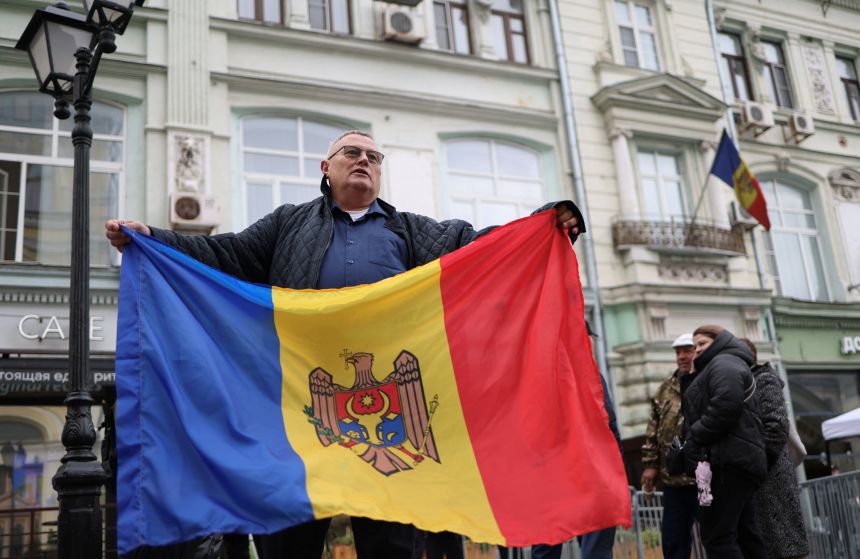 A man holds a Moldovan flag outside the Moldovan Embassy where citizens vote in parliamentary elections, in Moscow, Russia on September 28, 2025.