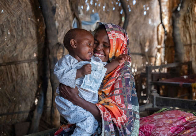 Anwar’s mother, Shama, plays with him inside their home in Al-Azaza.