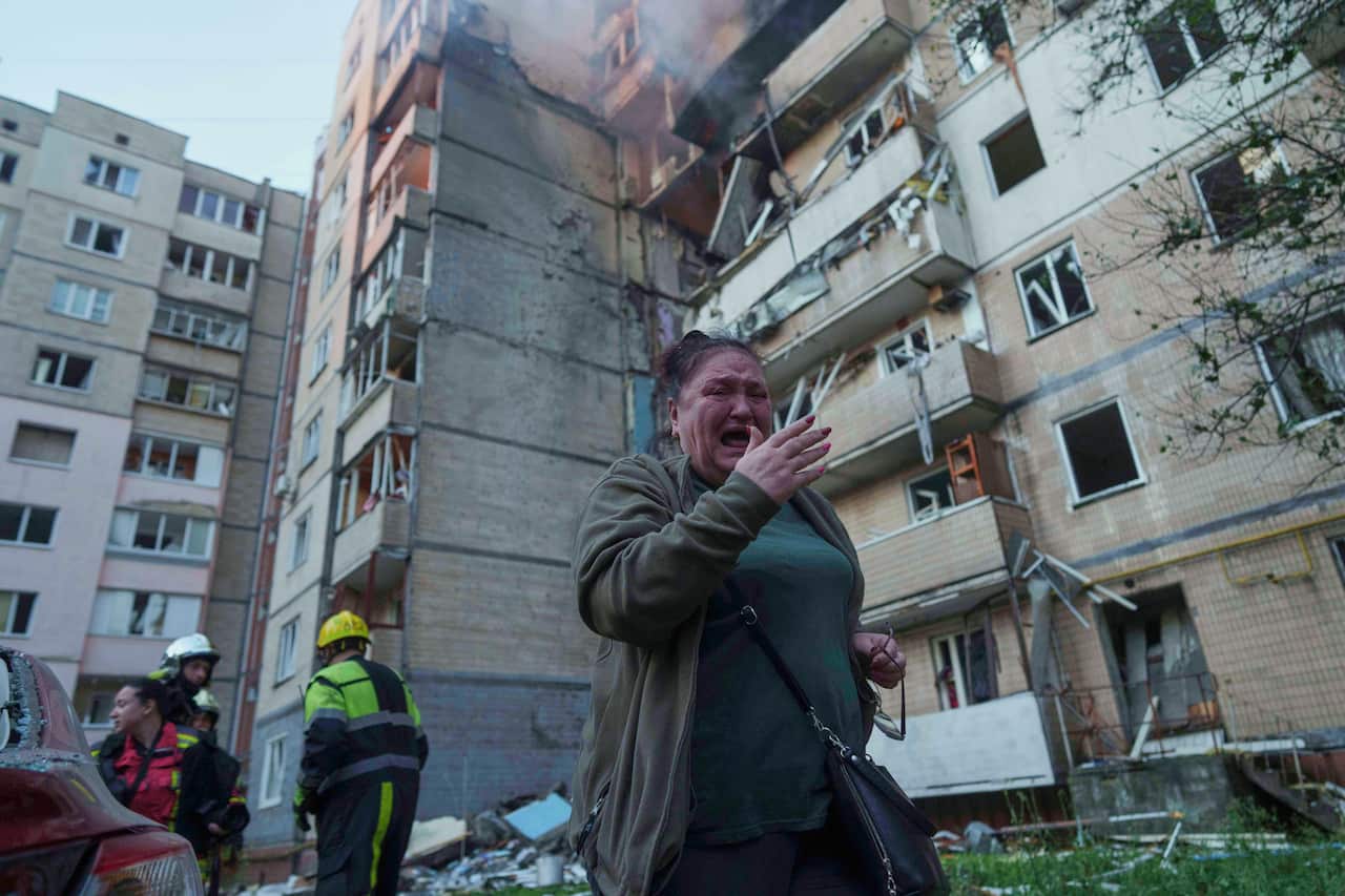 A woman cries fleeing a damaged building