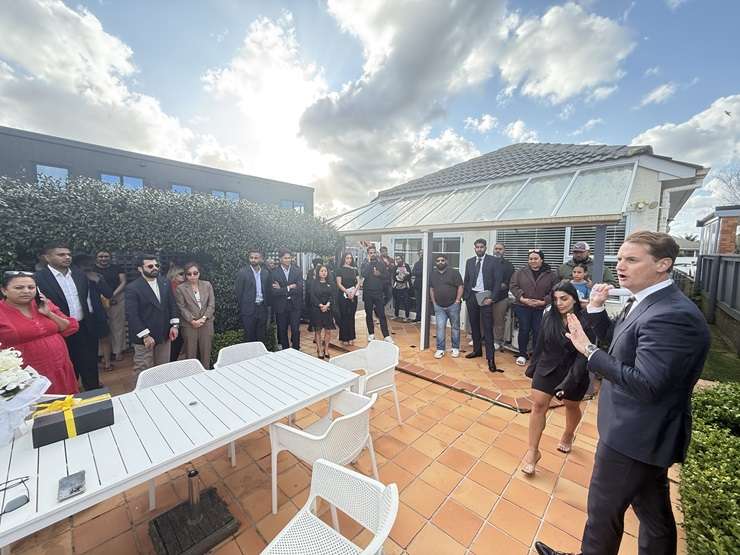 Mike King high-fives his agent after his cottage on Glen Avenue, in Papatoetoe, sold under the hammer. Photo / Supplied